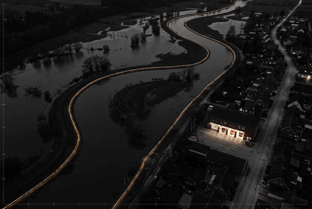 KI-Illustration: einen Fluss mit Hochwasser und eine Feuerwache bei Nacht (kein realer Ort)